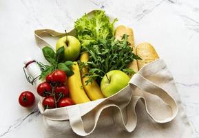 Öko-Naturtasche mit Obst und Gemüse, umweltfreundlich, flach gelegt foto