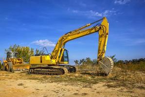 Tag Aussicht von Gelb Bulldozer und Bagger mit ein Schaufel nach arbeiten. foto