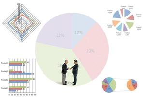 Miniaturgeschäftsleute, die mit Diagrammen auf einem weißen Hintergrund stehen foto