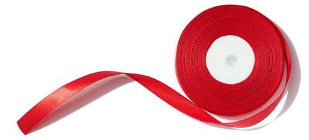 ein Spule mit ein rot Seide Band auf ein Weiß isoliert Hintergrund, ein Objekt zum Dekoration foto