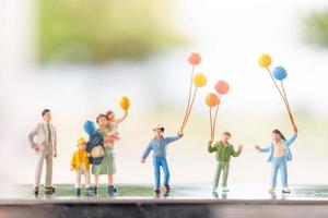 Miniaturfamilie mit Luftballons, glücklichen Familienbeziehungen und unbeschwertem Freizeitkonzept foto