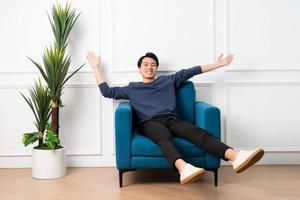 Porträt von asiatisch Mann Sitzung auf Sofa beim Zuhause foto