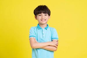Porträt von ein asiatisch Junge posieren auf ein Gelb Hintergrund foto