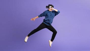 Bild von asiatisch Mann tragen virtuell Wirklichkeit Brille auf lila Hintergrund foto