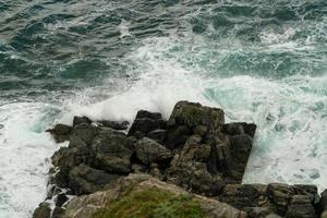 Seelandschaft mit Wellen, die auf Felsen krachen foto