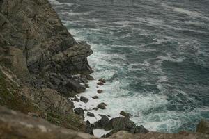 Seelandschaft mit Wellen, die auf Felsen krachen foto