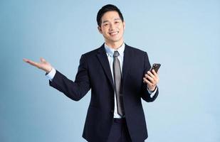 Porträt des asiatischen Geschäftsmannes im Anzug auf blauem Hintergrund foto
