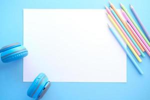 bunte Stifte mit leerem Papier auf blauem Hintergrund foto