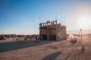 Menschen Gehen gegenüber Sonnenuntergang beim ein Festival im das Wüste beim das Verbrennung Mann Festival. foto