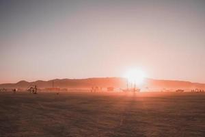 Menschen Gehen gegenüber Sonnenuntergang beim ein Festival im das Wüste beim das Verbrennung Mann Festival. foto