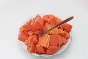 ein schließen oben von geschnitten Papaya erstochen mit ein Gabel foto