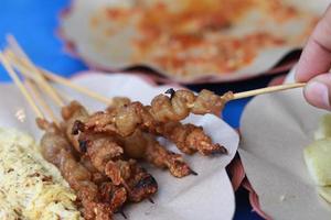 Foto von Hähnchen Darm Satay und serviert mit rot Chili Soße. indonesisch Essen namens stillen Taichan. Essen Konzept Foto.