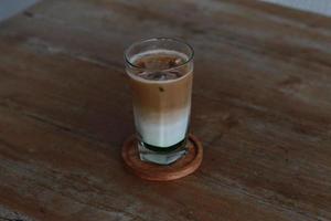 ein Glas von Pandan Kaffee Latté serviert kalt auf das Tisch. foto