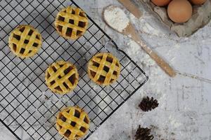 klein Apfel Kuchen serviert auf ein Kuchen Gestell, schmeckt Süss und Bohnenkraut. Essen Konzept Foto. foto