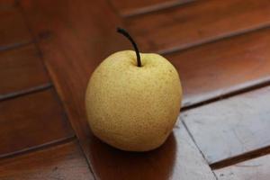 ein schließen oben von Birne isoliert natürlich Muster Holz Hintergrund. gesund Essen Konzept Foto. wasserreich Frucht. foto