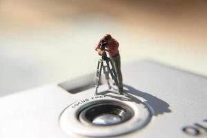 Miniatur Zahl von ein Videograf Aufzeichnung auf ein analog Kamera. foto