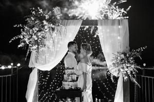 Jungvermählten schneiden glücklich die Hochzeitstorte an und probieren sie foto