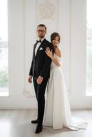 Bräutigam im ein schwarz passen Krawatte und das Braut im ein hell Studio foto