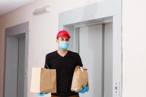 Lieferung Mann halten Karton Kisten im medizinisch Gummi Handschuhe. Quarantäne. Coronavirus. Tür Lieferung foto