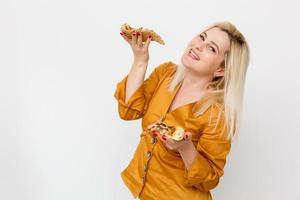 schön blond Frau essen Stück von Pizza foto