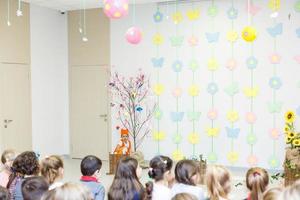 jung Darstellerin im ein Fuchs Kostüm Sprechen im Vorderseite von Kinder foto