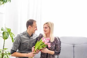 Paar im Liebe mit ein Strauß von Tulpen sind schließen zu jeder andere foto