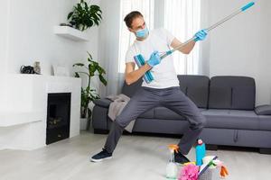 Reinigung, Gesundheit und Hygiene Konzept - - indisch Mann tragen schützend medizinisch Maske zum Schutz von Virus Krankheit im Handschuhe mit Waschmittel und Mopp beim Zuhause foto