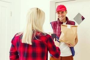 jung gut aussehend Mann liefern Essen im ein Wohnung foto