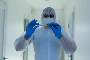 Wissenschaftler im schützend Ausrüstung mit Waffen gekreuzt im Labor foto