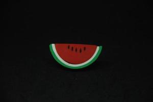 geschnitten rot Wassermelone geformt Radiergummi stationär Werkzeuge zum Büro oder Schule Lieferungen. isoliert Foto auf einfach dunkel schwarz Hintergrund.
