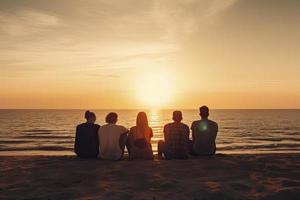 Gruppe von fünf glücklich Menschen sitzt auf Hintergrund von leeren Sonnenuntergang Strand. Reise oder Meer Urlaube Konzept foto