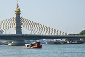 Abend Aussicht von Fluss Suspension Brücke und Boote im Bangkok, Thailand foto