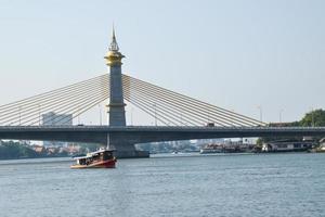 Abend Aussicht von Fluss Suspension Brücke und Boote im Bangkok, Thailand foto