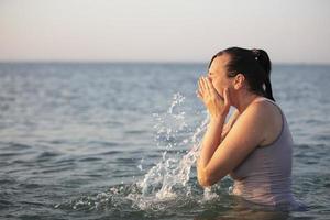 ein mittleren Alters Frau ist Schwimmen im das Meer. foto