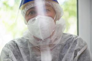 Arzt im ein schützend Maske und passen zum Coronavirus Infektion. foto