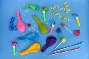 Süssigkeit, Pfeifen, Streamer, Luftballons auf Urlaub Tisch. Konzept von Kinder- Geburtstag Party. Aussicht oben. foto