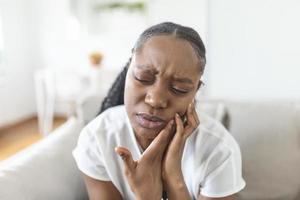 Porträt von unzufrieden Afroamerikaner Frau Leiden von Zahnschmerzen beim heim. Gesundheitspflege, Dental Gesundheit und Problem Konzept. Lager Foto