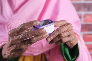 Hand der älteren Frau mit Pulsoximeter foto
