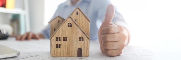 Daumen hoch Hand des Bankagenten bestätigt Immobilienerfolg, Konzept