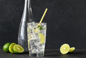 Glas Sprudelwasser mit Eiswürfeln und Limettenscheibe foto