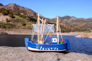 Spielzeug Schiff auf das Felsen foto