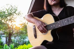 Frau spielt draußen Gitarre foto