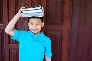 Junge mit Büchern auf dem Kopf foto