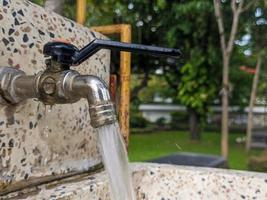 ein schließen oben von ein Wasser Wasserhahn emittieren Wasser foto