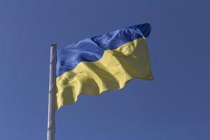 ukrainisch Zustand Flagge auf Fahnenstange gegen Blau Himmel foto