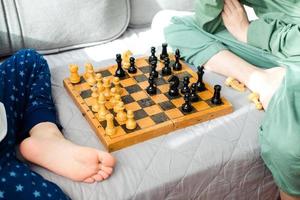 zwei Kinder sind spielen Schach Nahansicht. macht ein Ritter und Pfand Bewegung foto