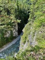 Berg Fluss fließend im ein Senke zwischen ein Wald und ein hoch Cliff, Burjatien, Russland foto