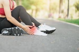 jung Erwachsene weiblich mit seine Muskel Schmerzen während Betrieb. Läufer Frau haben Bein schmerzen fällig zu Knöchel Verstauchungen oder Achilles Sehnenentzündung. Sport Verletzungen und medizinisch Konzept foto