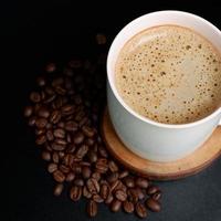 Kaffee trinken Thema Foto zum spotten hoch, ein Tasse von Kaffee und Kaffee Bohnen mit leeren Bereich im das Mitte, mit dunkel Farbe Hintergrund, Platz Bild Format