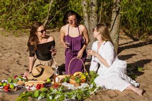 heiter Freundinnen sind haben Spaß im Sommer- beim Picknick. foto